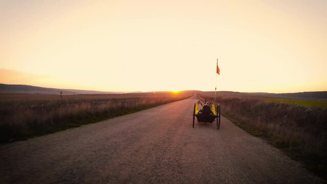 Scenic Shot of a Young Man Athlete with disability Riding a Handcycle. Adaptive Exercise Outdoors at Sunset . High quality 4k footage