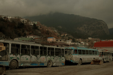 Abandoned trolleybuses against the backdrop of mountains in the Crimea