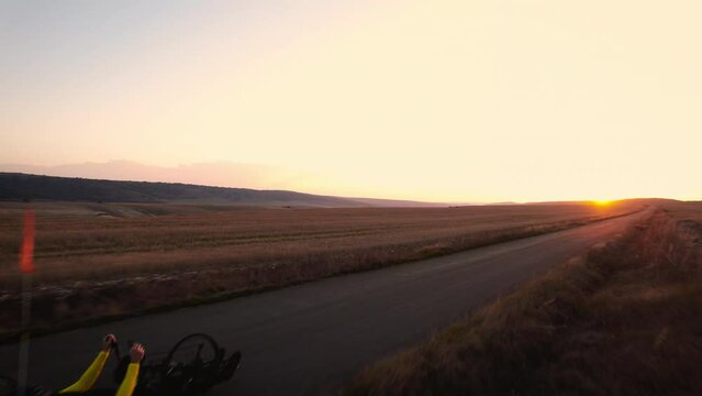 Scenic Shot of a Young Man Athlete with disability Riding a Handcycle. Adaptive Exercise Outdoors at Sunset . High quality 4k footage