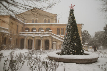 Christmas tree decorated with golden balls on the background of the building