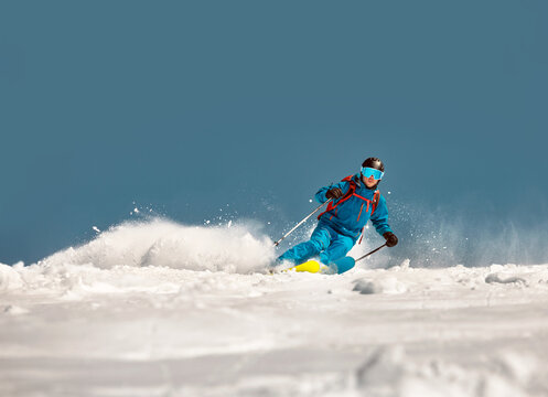Fast skier rides downhill at ski resort. Offpiste freeride concept