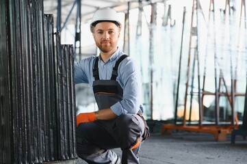 Workers transfer the glass. At the factory for the production of windows and doors of aluminum and...