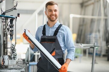 Manual worker cutting aluminum and PVC profiles. Manufacturing jobs. Selective focus. Factory for aluminum and PVC windows and doors production.