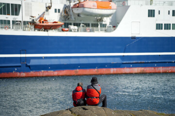 Zwei Personen beobachten Schiffe in Tórshavn auf den Färöer Inseln