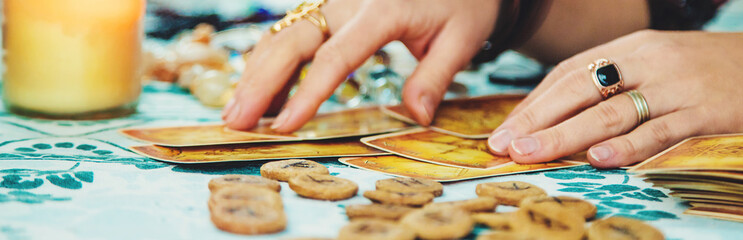 A fortune teller reads with tarot cards. Selective focus.