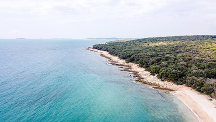Rocky beach with blue sea at Cisterna Beach near Rovinj