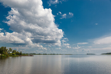 beautiful summer view of the water, river, sea overlooking the blue sky with clouds