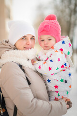 Portrait of a young beautiful mother with a little daughter in a winter city.