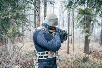 Naklejka premium An armed soldier patrols the forest