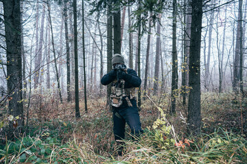 An armed soldier patrols the forest