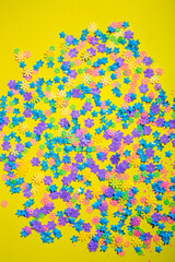 Fototapeta na wymiar Abstract background of colored flowers on a yellow background