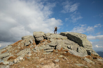 a young woman with a dog on top of a stone mountain
