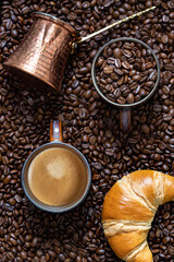 Cup of coffee, , coffee beans, turk and croissant.