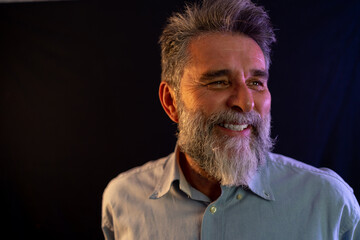 Neon light studio close-up portrait of serious man model with mustaches and beard