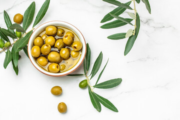 Branch with olives and a bottle of olive oil on white background. top view. place for text