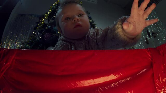 Portrait sweet little asian baby boy at background of decorated fir-tree open red wrapped box with surprise of Christmas. Happy cute kid unpack present or gift. Merry xmas, happy new year love concept