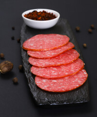 Sliced sausage slices on a dark background. Shallow depth of field