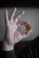 Hand holding and showing a golden Bitcoin, - 546641787