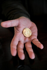 Hand holding and showing a golden Bitcoin, - 546641795