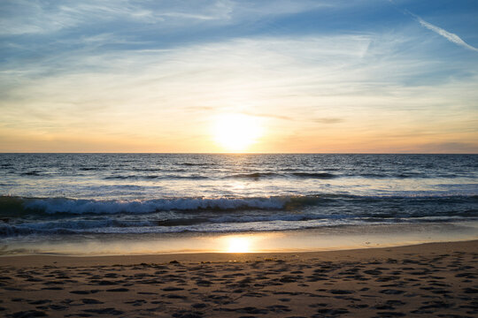 Scenic view of sea against cloudy sky during sunset