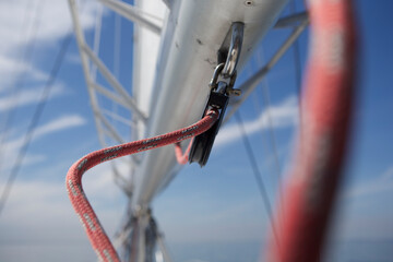 Low angle view of rope on pulley against blue sky during sunny day