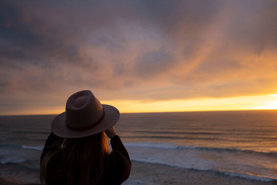Woman looking at scenic ocean sunset