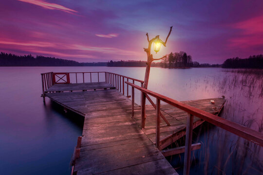 Illuminated Wooden Jetty Under Dramatic Sky At Dusk, Lithuania