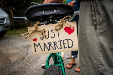 A sign reading Just Married is attached to the rear of a tandem bicycle.