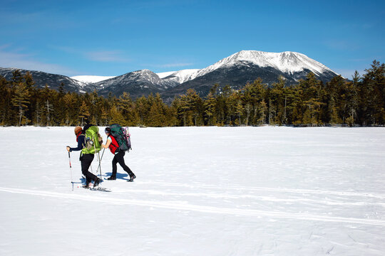 Snowshoers crossing a frozen pond in Baxter State Park.