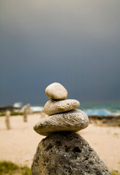 Stacks of rocks are placed on a beach for good luck under a threatening sky.
