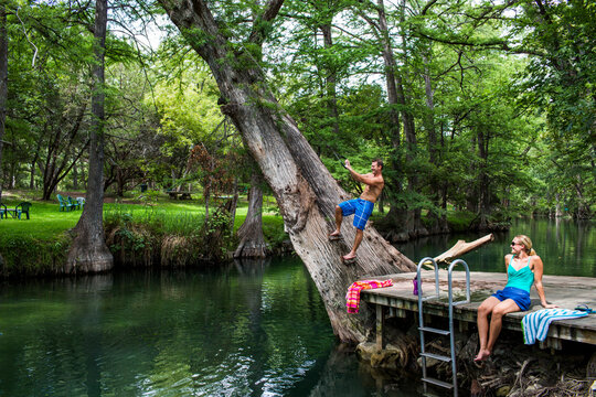 The Blue Hole in Wimberley, Texas is a popular destination for tourists and locals on hot summer days. The clear, cool water flows through cypress trees and offers a refuge from th