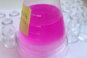 The deep pink alkaline solution colored with the indicator dye phenolphthalein in a conical flask.