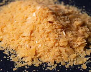 A handful of Carnauba wax on a black background