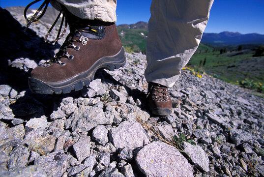 A female hiker goes up a rocky trail.