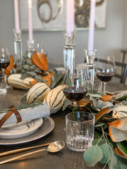 Autumn table setting with fresh pumpkins and flowers in room, Thanksgiving concept