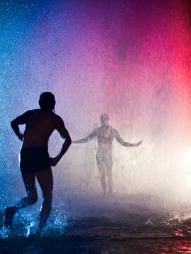 People dance beneath the downpour produced by a broken fire hydrant in Venice, Californial