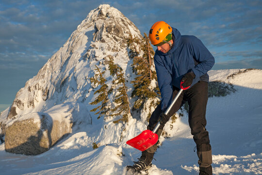 A mountaineer uses his snow shovel.