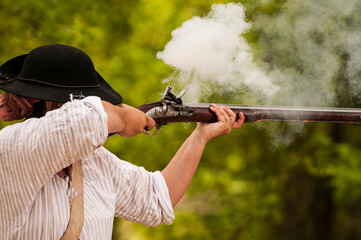 Historical reenactor firing a musket in Jamestown, Virginia.