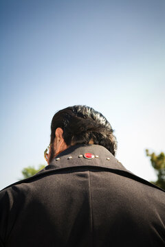 Rear view of an Elvis impersonator in a black suit.