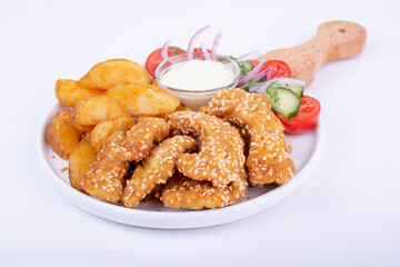 Delicious chicken breast strips, crispy, fried and breaded, served with potato, fresh salad and sauce.	