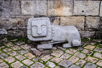 Stone sculpture of a lion on the old cobblestones of the old town.