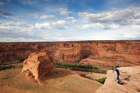 A photographer shoots rock formations in Canyon de Chelly, Arizona