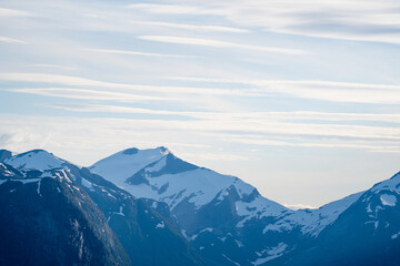mountain landscape with a big deep valley that is between big mountains whose gray stone surface is...