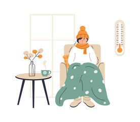 Young woman wrapped in plaid. Low house temperature and thermometer on wall. Person freezes from cold warming up with hot drink. Young woman sitting in armchair, shivering from cold.