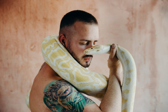 man holding a python near his face