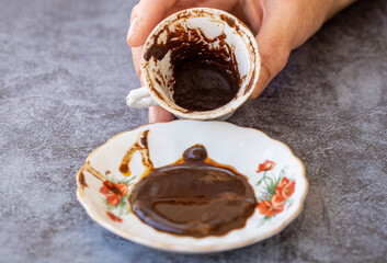 The fortune teller makes predictions on the coffee grounds on the table.
