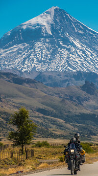 Couple on touring motorbike. Lanin volcano in the back, Argentina