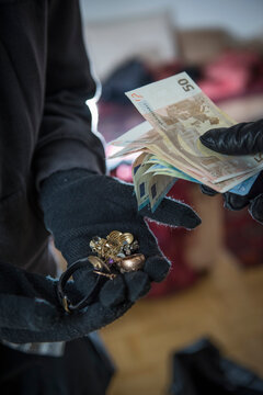 Burglars stealing jewelry and Euro banknotes