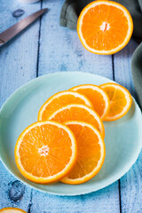 Fresh juicy sliced orange on a plate on the table. Healthy food. Vertical view