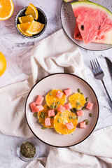 Fresh salad of orange, watermelon and pumpkin seeds on a plate. Organic diet. Top and vertical view